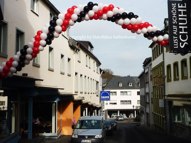 schwebender Ballonbogen mit Helium zum Jubiläum in Prüm in der Eifel über die Straße gespannt